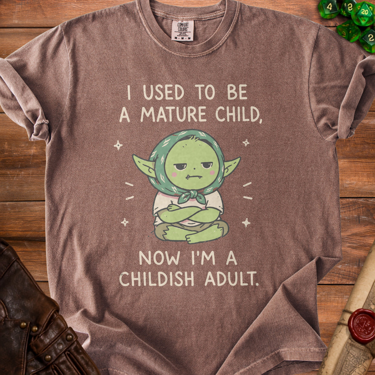 Brown t-shirt with "I USED TO BE A MATURE CHILD, NOW I'M A CHILDISH ADULT." text.