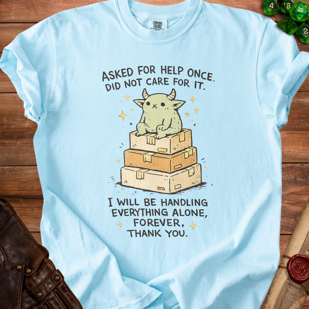 Light blue t-shirt with a cartoon creature on boxes, text reads "Asked for help once. Did not care for it. I will be handling everything alone, forever, thank you."