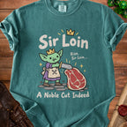 Green t-shirt with a cartoon goblin holding a sword over a steak, text reads "Sir Loin" and "A Noble Cut Indeed".