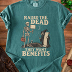 Green t-shirt with skeleton and grim reaper graphic reading "Raised the Dead, They Want Benefits."