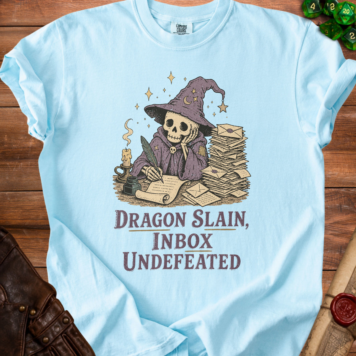 Light blue t-shirt with skeleton wizard writing, saying "Dragon Slain, Inbox Undefeated".