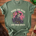 Green t-shirt with a skeleton in a witch hat playing a tambourine and holding a party hat.