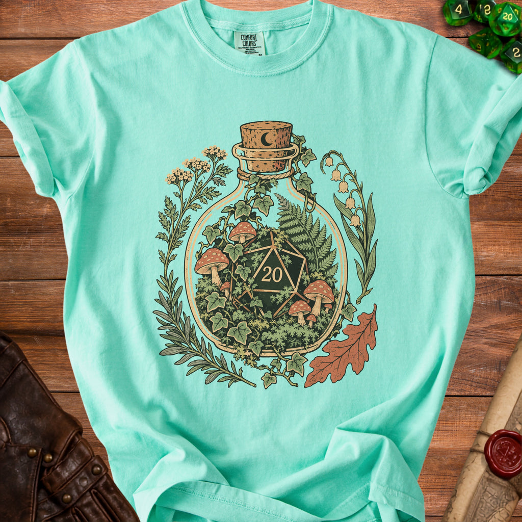 Mint t-shirt with a bottle illustration containing a D20 die and forest elements.