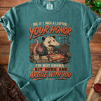 Teal t-shirt with graphic of a possum lawyer saying "I'm not gonna sit here and argue with you."