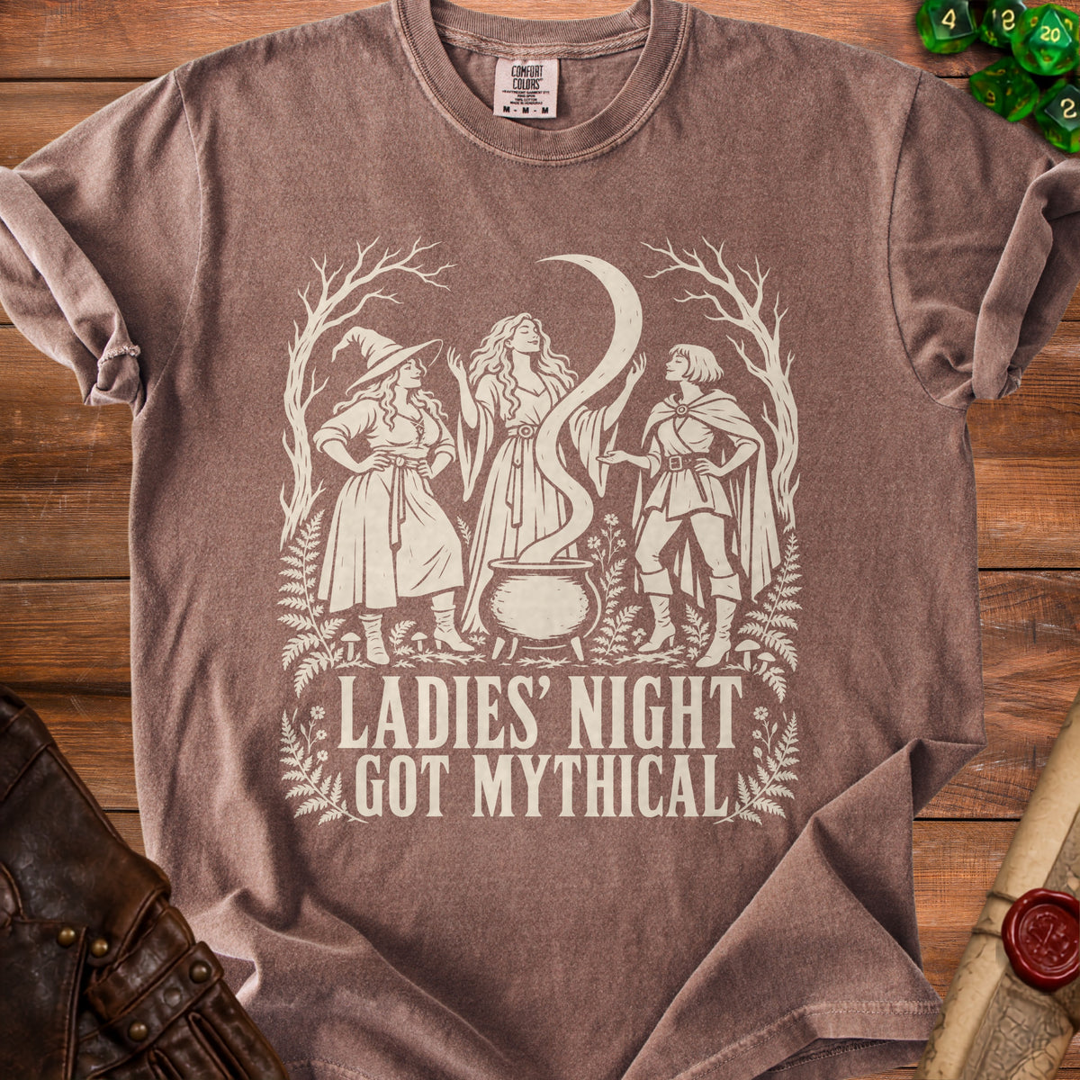 T-shirt graphic of three women around a cauldron with text "LADIES' NIGHT GOT MYTHICAL".