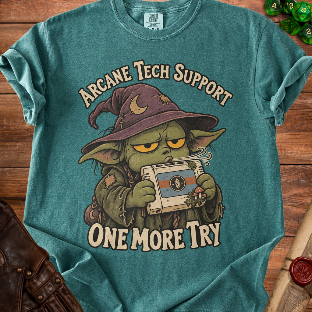 T-shirt graphic of a goblin wizard holding a retro console, "Arcane Tech Support One More Try" text.