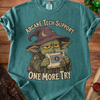 T-shirt graphic of a goblin wizard holding a retro console, "Arcane Tech Support One More Try" text.