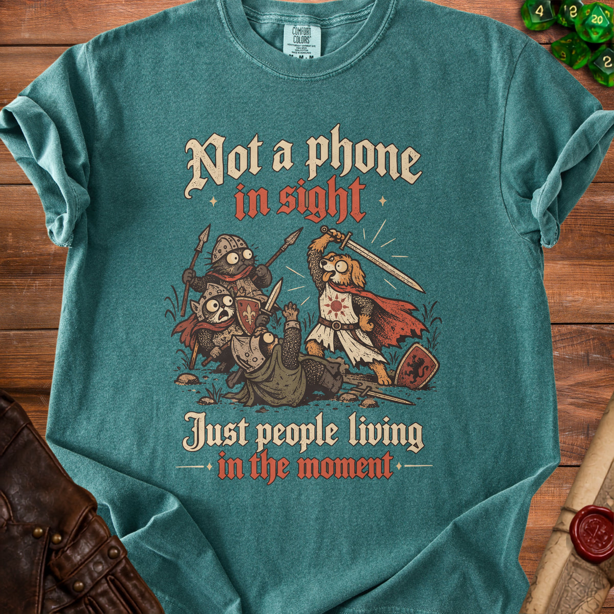 T-shirt with cartoon cats and dogs in medieval armor fighting, text "Not a phone in sight, Just people living in the moment."