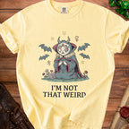 Yellow t-shirt with a graphic of a spider-like creature and the text "I'M NOT THAT WEIRD".
