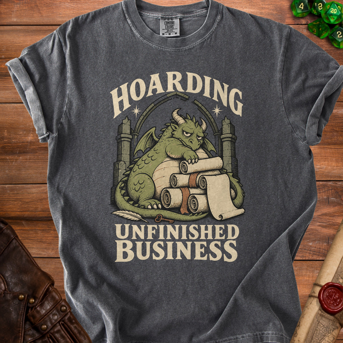 T-shirt with dragon hoarding scrolls, text "Hoarding Unfinished Business".