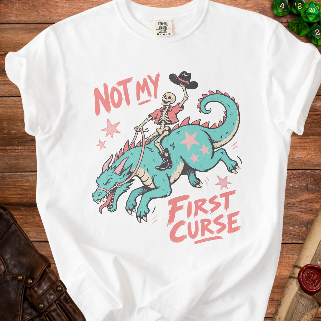 White t-shirt with skeleton riding dragon, text "NOT MY FIRST CURSE".