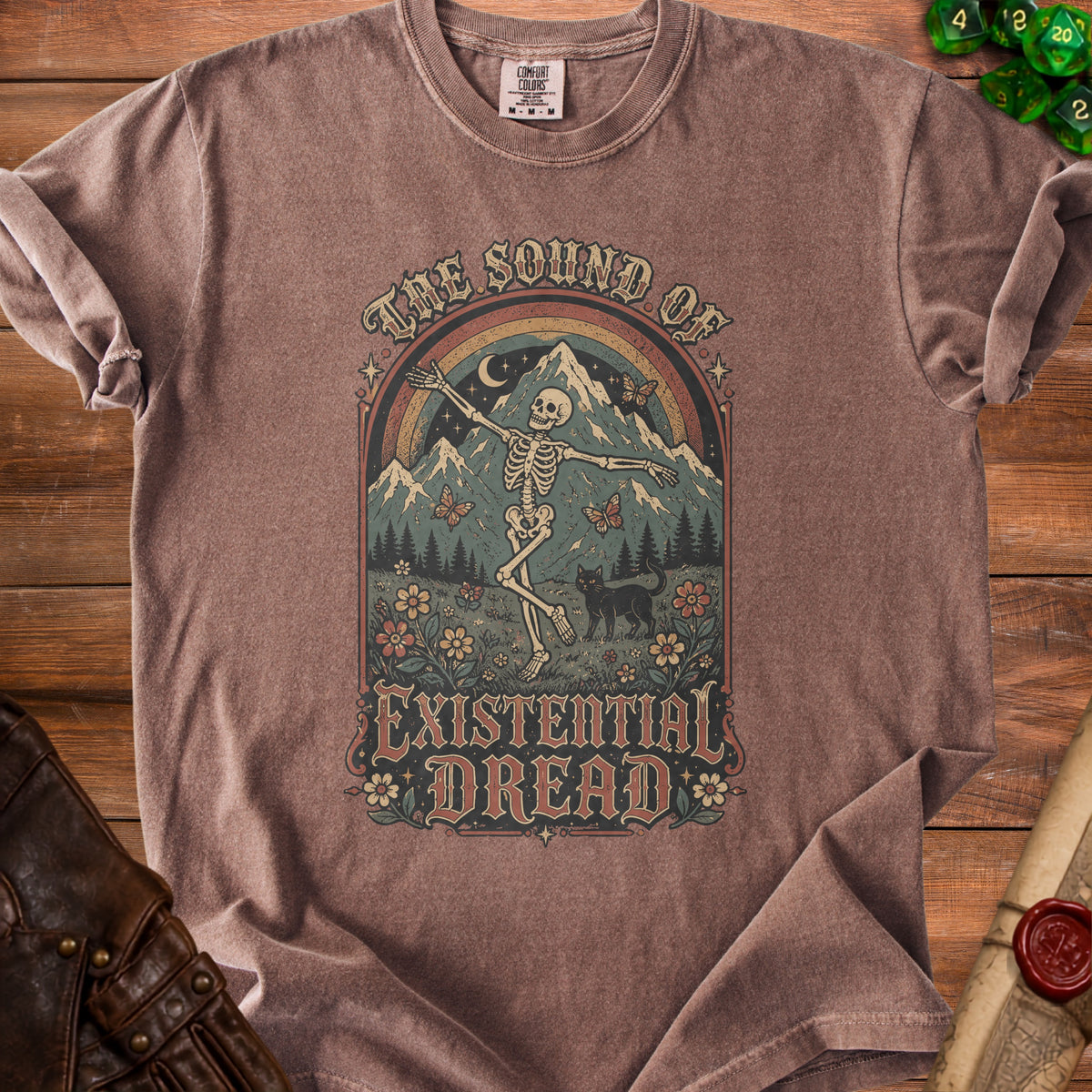 T-shirt with a skeleton dancing under a rainbow, mountains, and the text "The Sound of Existential Dread".