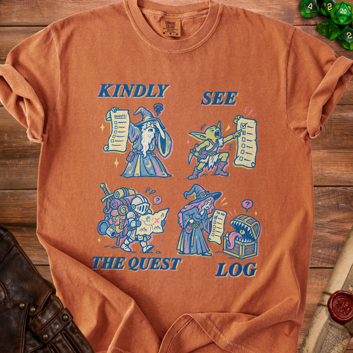 Orange t-shirt with fantasy characters and text "Kindly See The Quest Log".