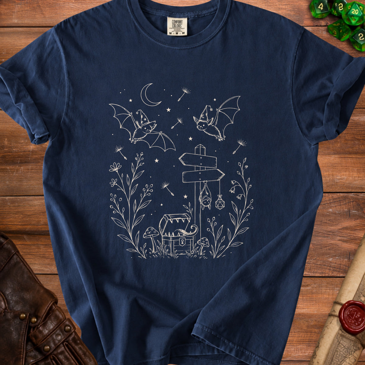 Dark blue t-shirt with white line art of bats, treasure chest, mushrooms, and celestial elements.