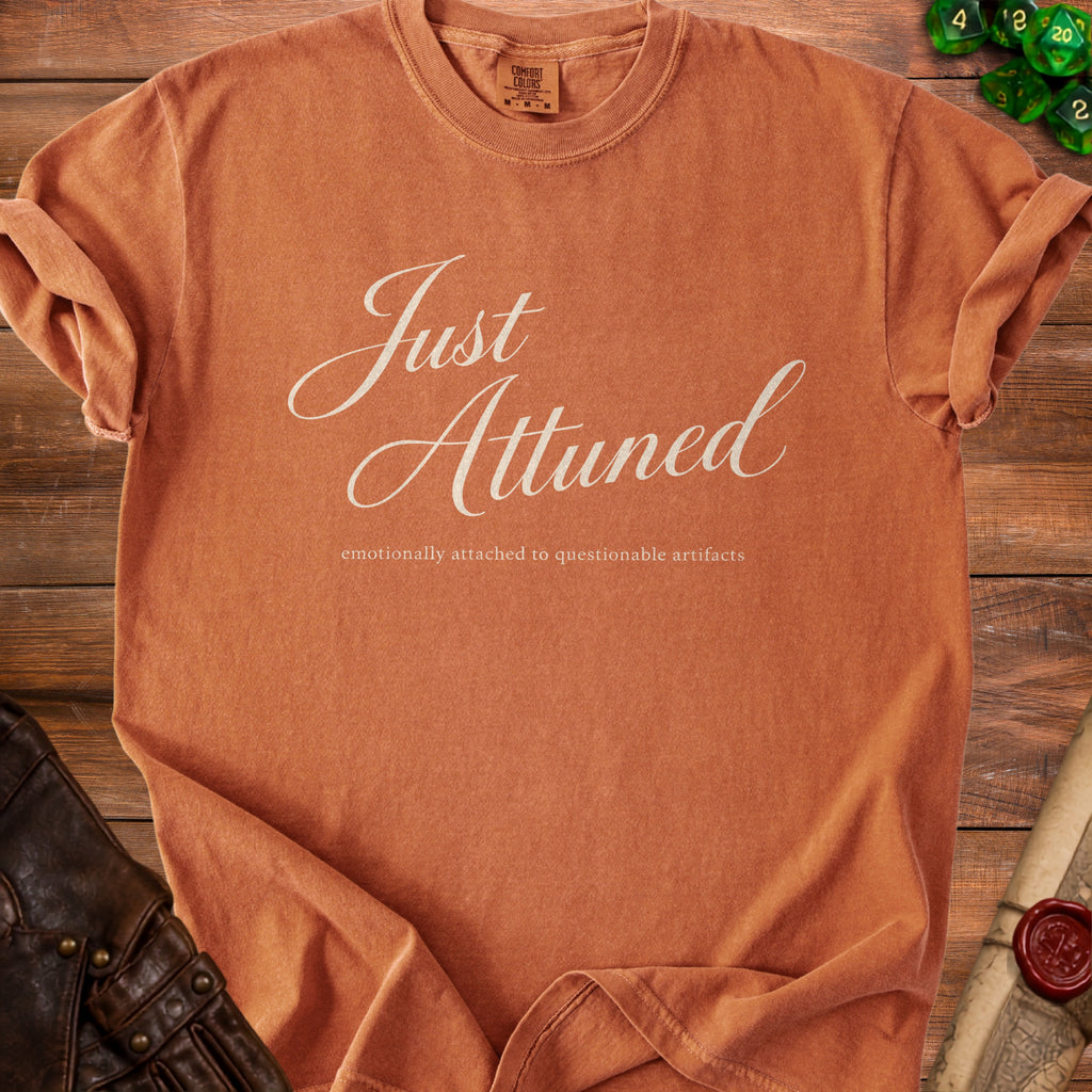 Orange t-shirt with "Just Attuned" and "emotionally attached to questionable artifacts" text.