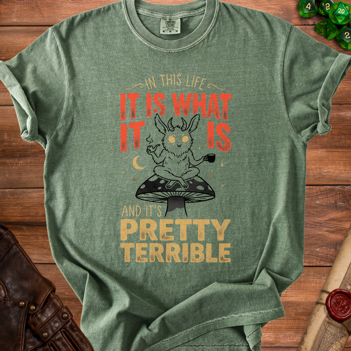 Green t-shirt with "In this life, it is what it is and it's pretty terrible" text.