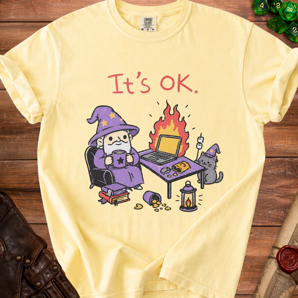 Yellow t-shirt with cartoon wizard, cat, and laptop on fire, reading "It's OK."