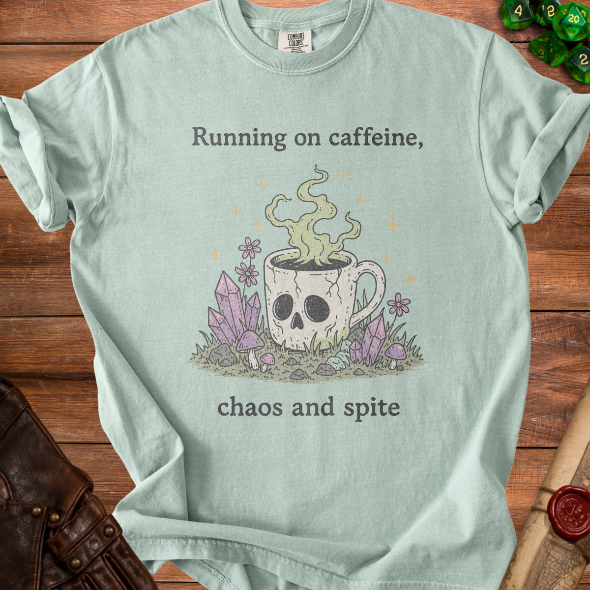 Light blue t-shirt with skull coffee mug graphic and text "Running on caffeine, chaos and spite."