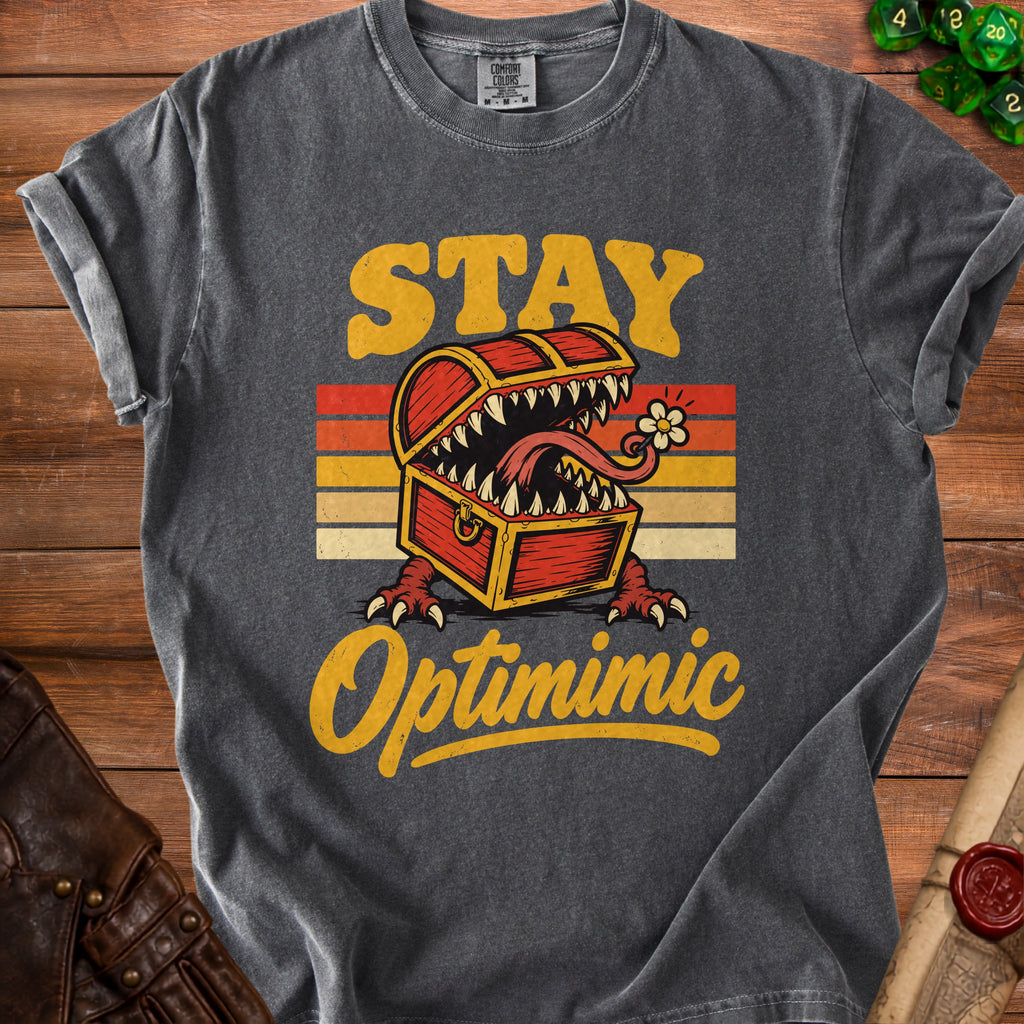 Dark grey t-shirt with "STAY Optimimic" text and a monster treasure chest graphic.