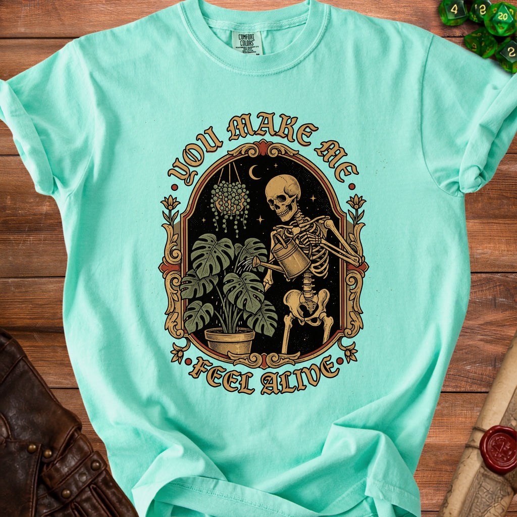 Skeleton watering plants with text "YOU MAKE ME FEEL ALIVE".