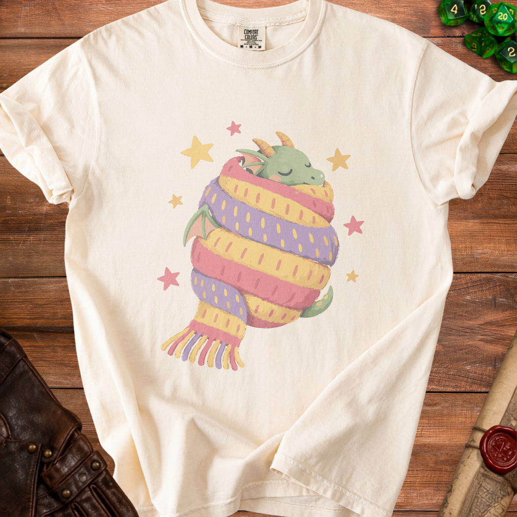 Cream t-shirt with a green dragon wrapped in a striped scarf and stars.