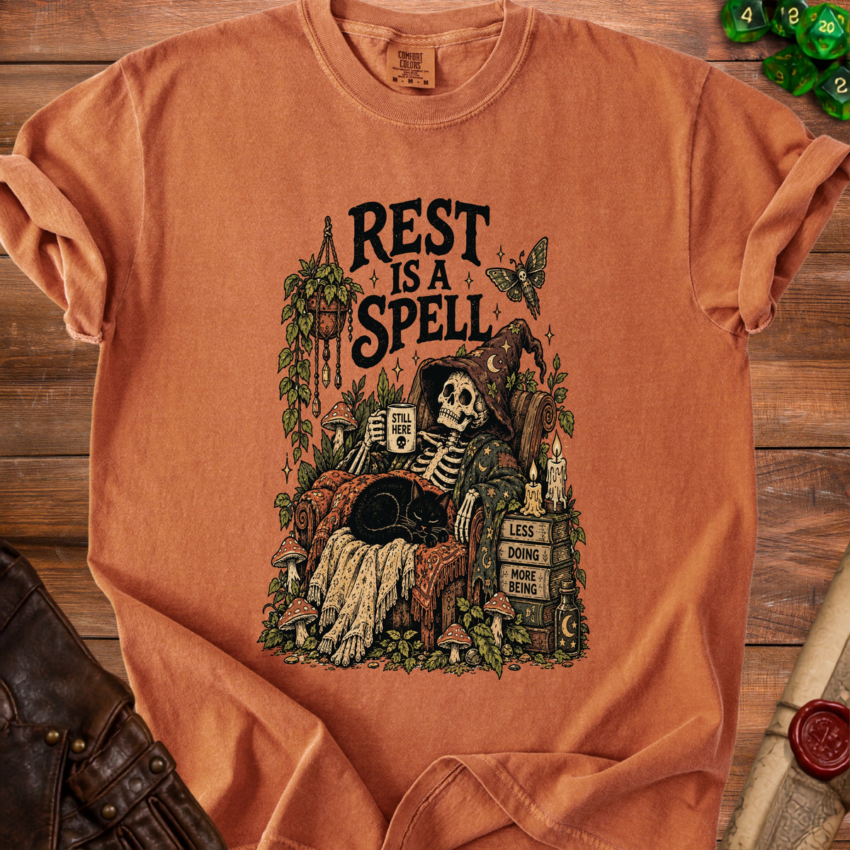 Skeleton in witch hat rests with cat, holding mug and reading books. Text: "Rest is a spell".