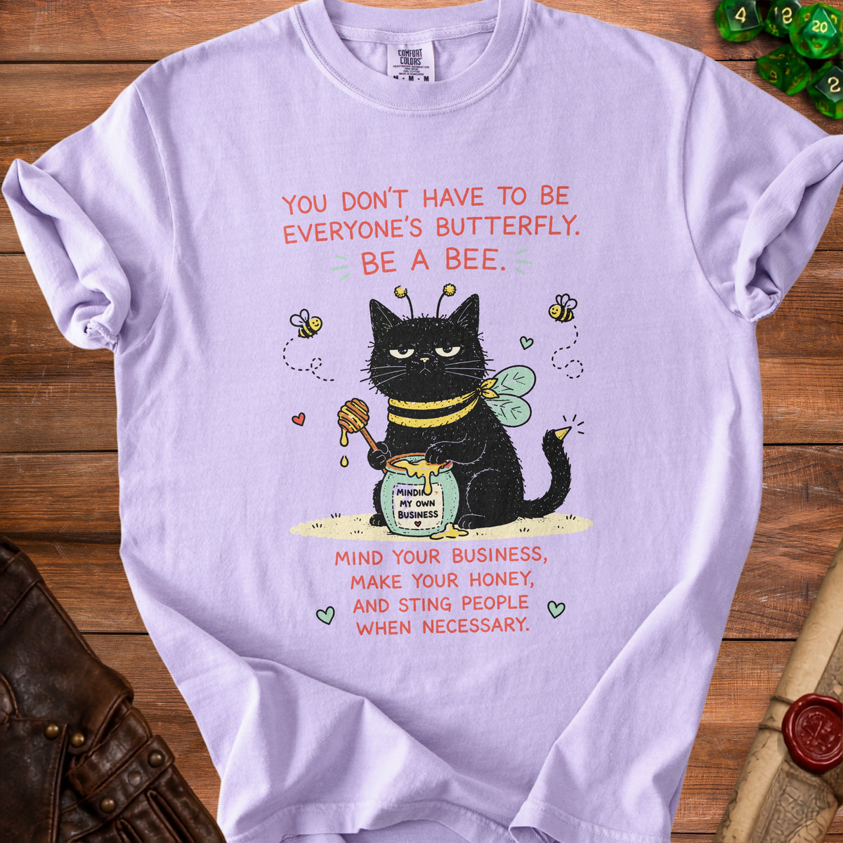 Purple t-shirt with a black cat wearing a bee costume and the text "Mind Your Business, Make Your Honey, And Sting People When Necessary."