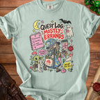 T-shirt with "Quest Log: Mostly Errands" text and fantasy-themed cartoon illustrations.