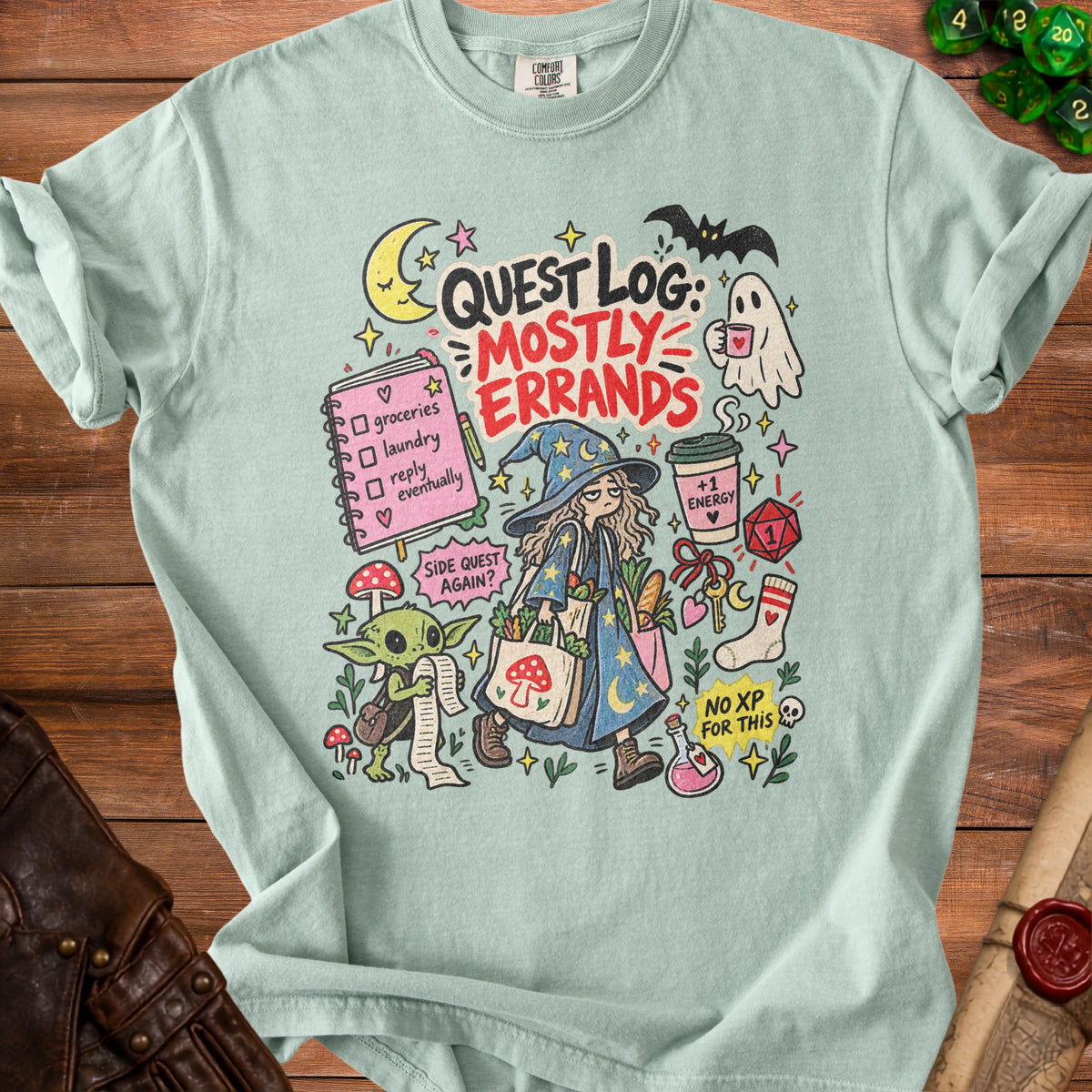T-shirt with "Quest Log: Mostly Errands" text and fantasy-themed cartoon illustrations.