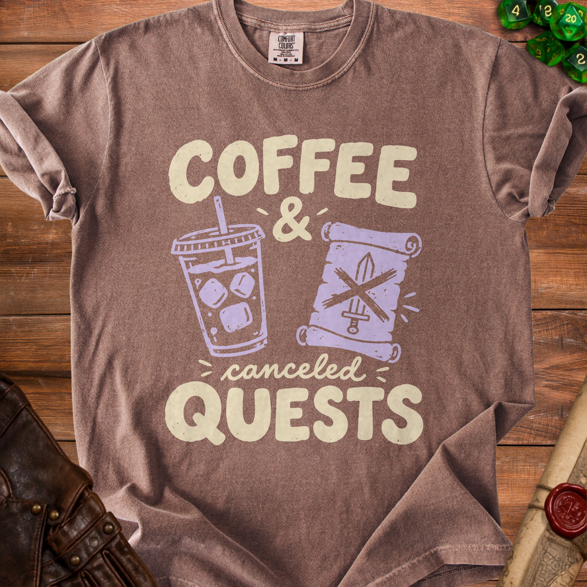 Brown t-shirt featuring the text "COFFEE & canceled QUESTS" with graphics of an iced coffee and a scroll.