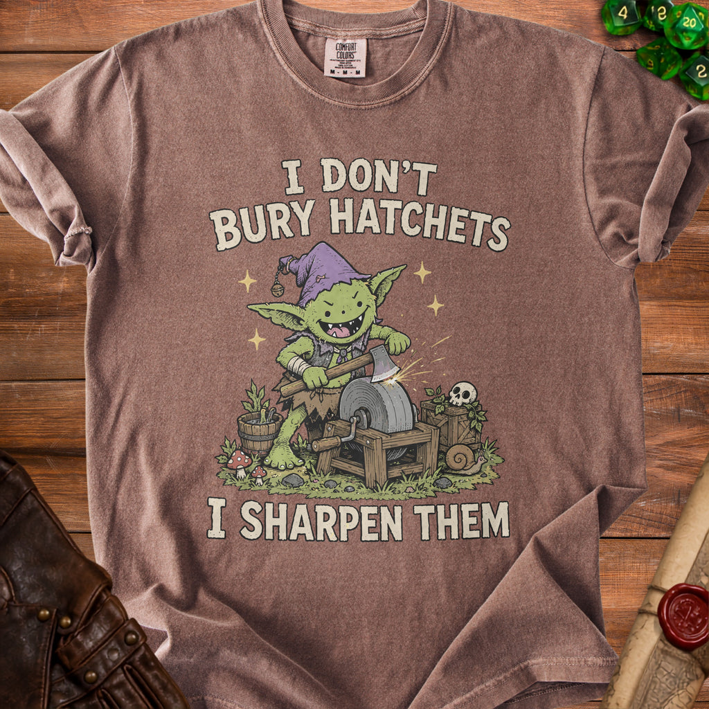Brown t-shirt with a goblin sharpening an axe with text "I DON'T BURY HATCHETS I SHARPEN THEM".
