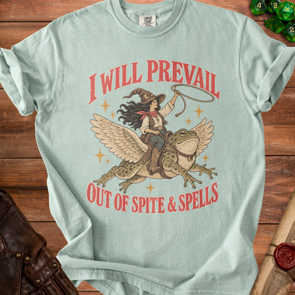 Light blue t-shirt with graphic of witch riding frog, "I Will Prevail Out of Spite & Spells" text.