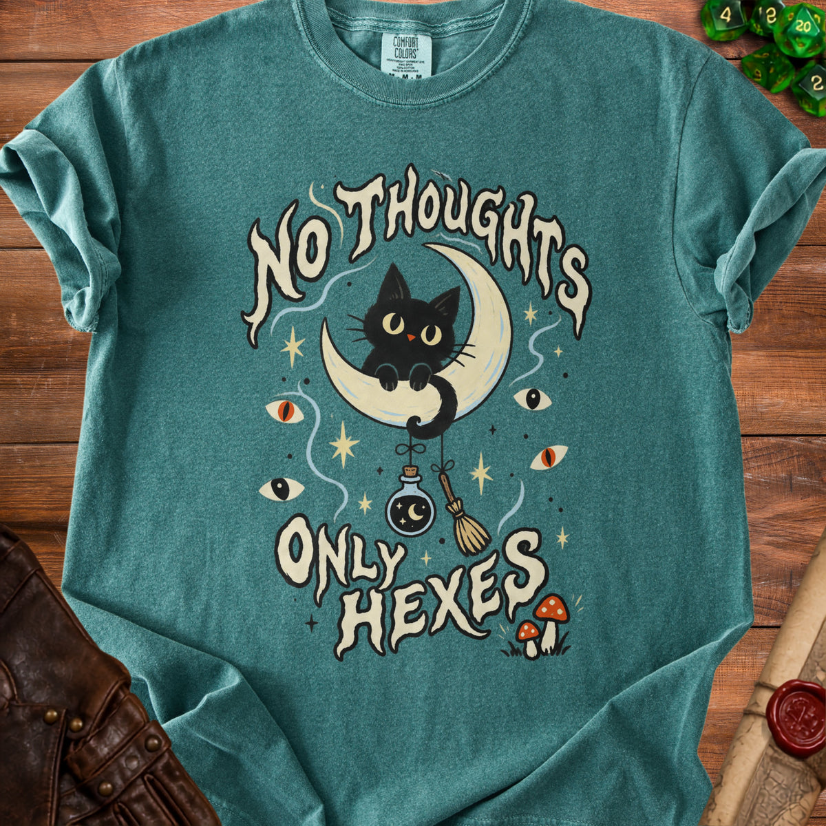 Teal t-shirt with black cat on moon, text "No Thoughts Only Hexes", potion, broom, eyes.