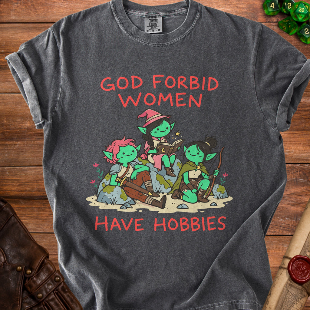 Graphic tee with red text "GOD FORBID WOMEN HAVE HOBBIES" and illustration of goblins.