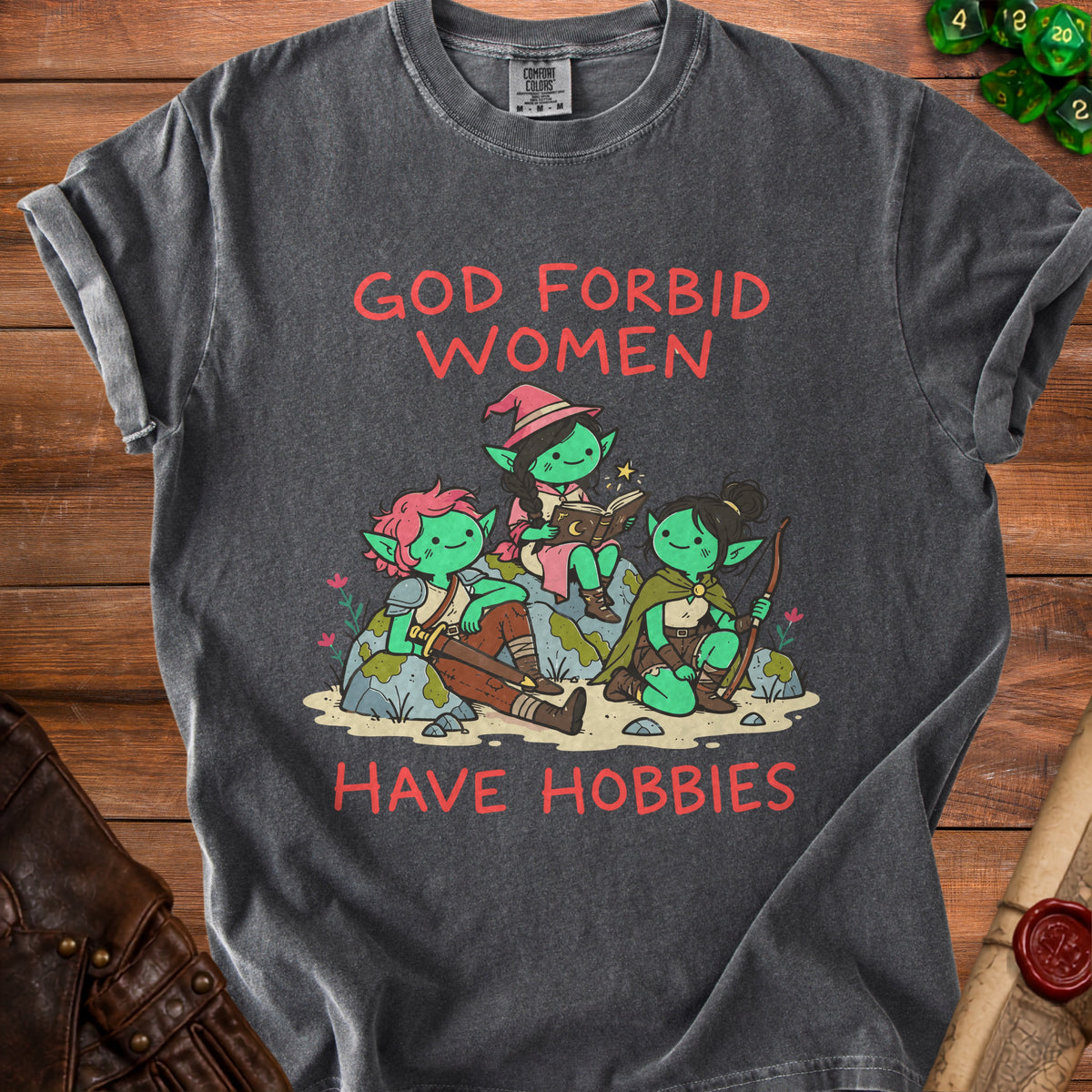 Graphic tee with red text "GOD FORBID WOMEN HAVE HOBBIES" and illustration of goblins.