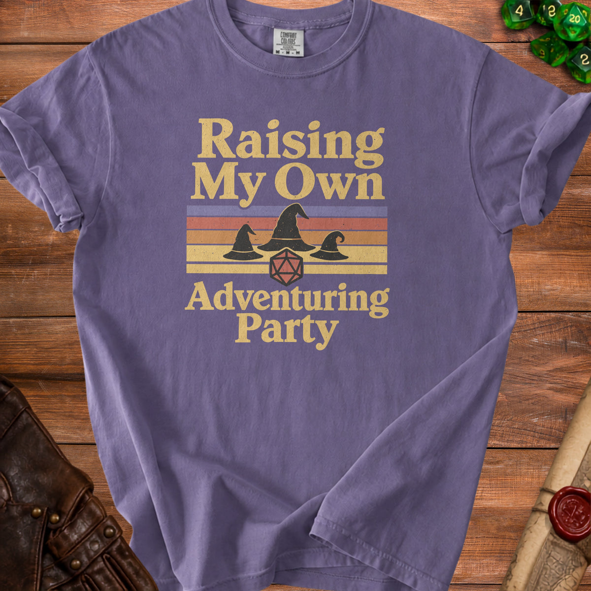 Purple t-shirt with "Raising My Own Adventuring Party" text and wizard hats.