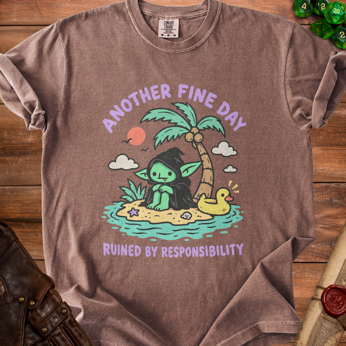 Brown t-shirt with cartoon goblin on beach, text "Another Fine Day Ruined By Responsibility".