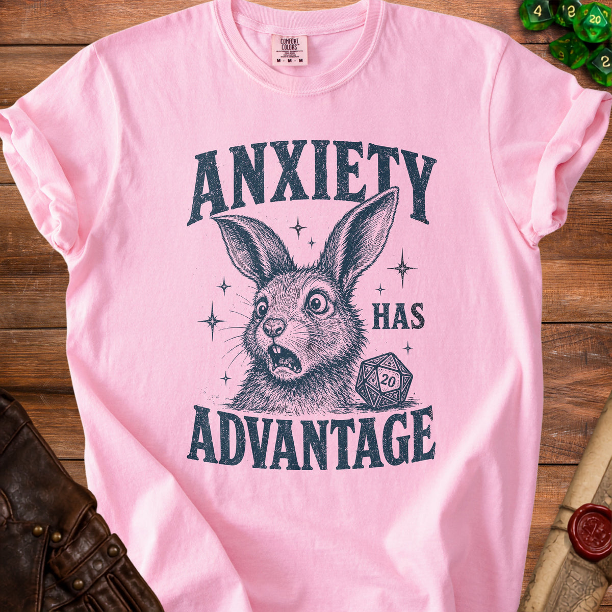 Pink t-shirt with distressed print of a startled rabbit and dice reading "ANXIETY HAS ADVANTAGE".