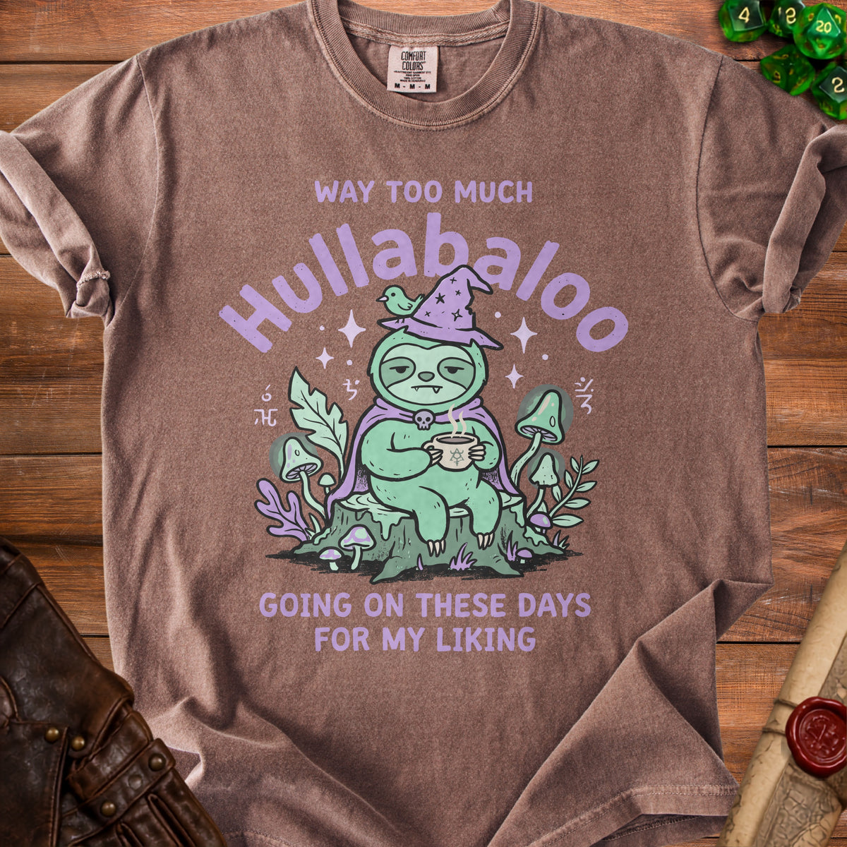 Brown t-shirt with graphic of a sloth in a witch hat drinking tea.