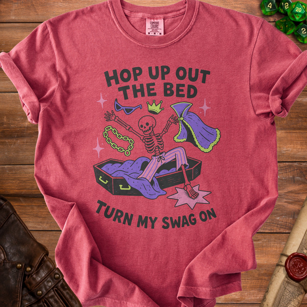 Skeleton in coffin with crown, sunglasses, chain, and cape, text says "Hop Up Out The Bed Turn My Swag On"