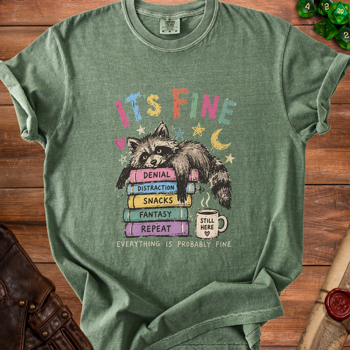 Green t-shirt with raccoon on books saying "It's Fine" and "Everything is Probably Fine".