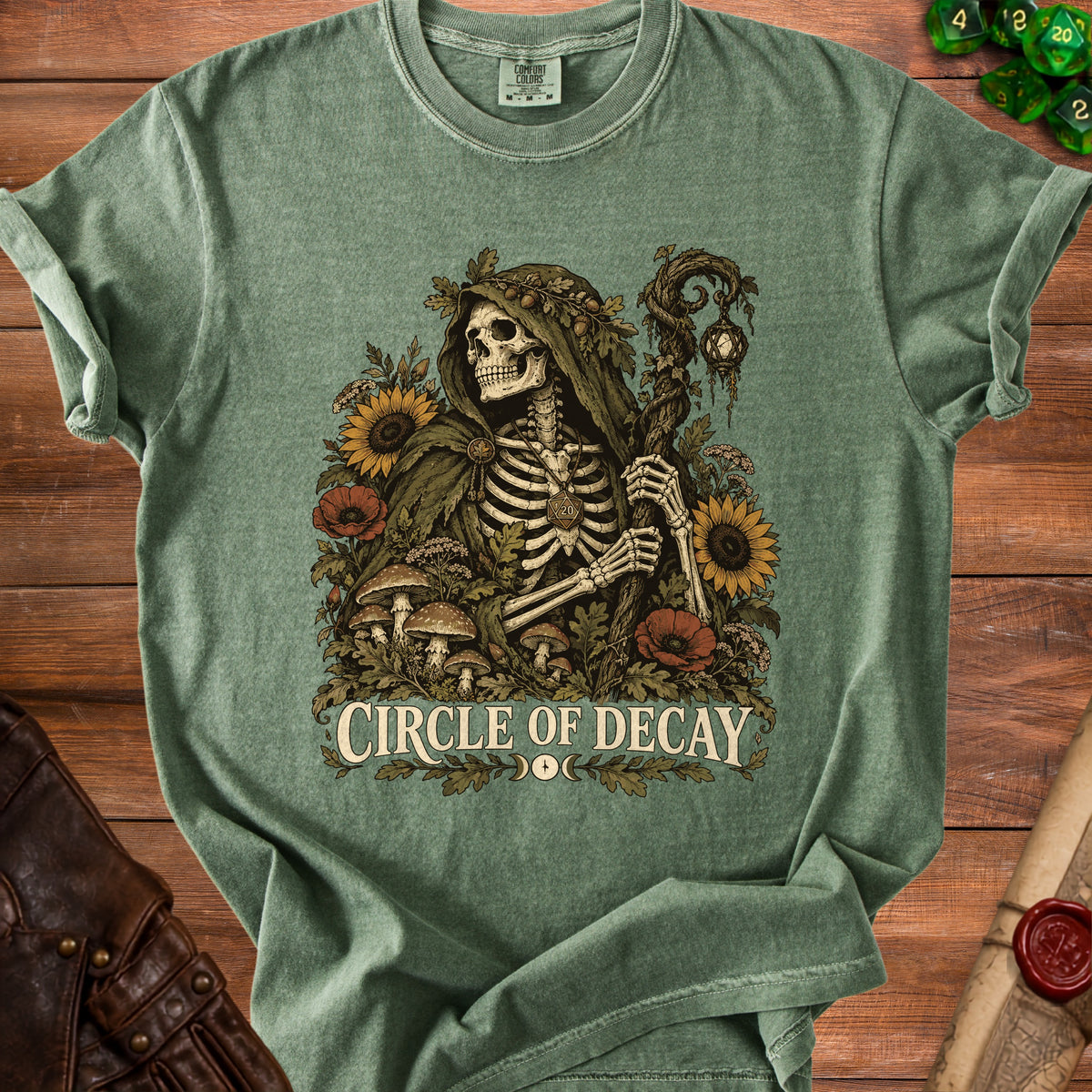 Green t-shirt with skeleton in cloak, surrounded by flowers and text "CIRCLE OF DECAY".