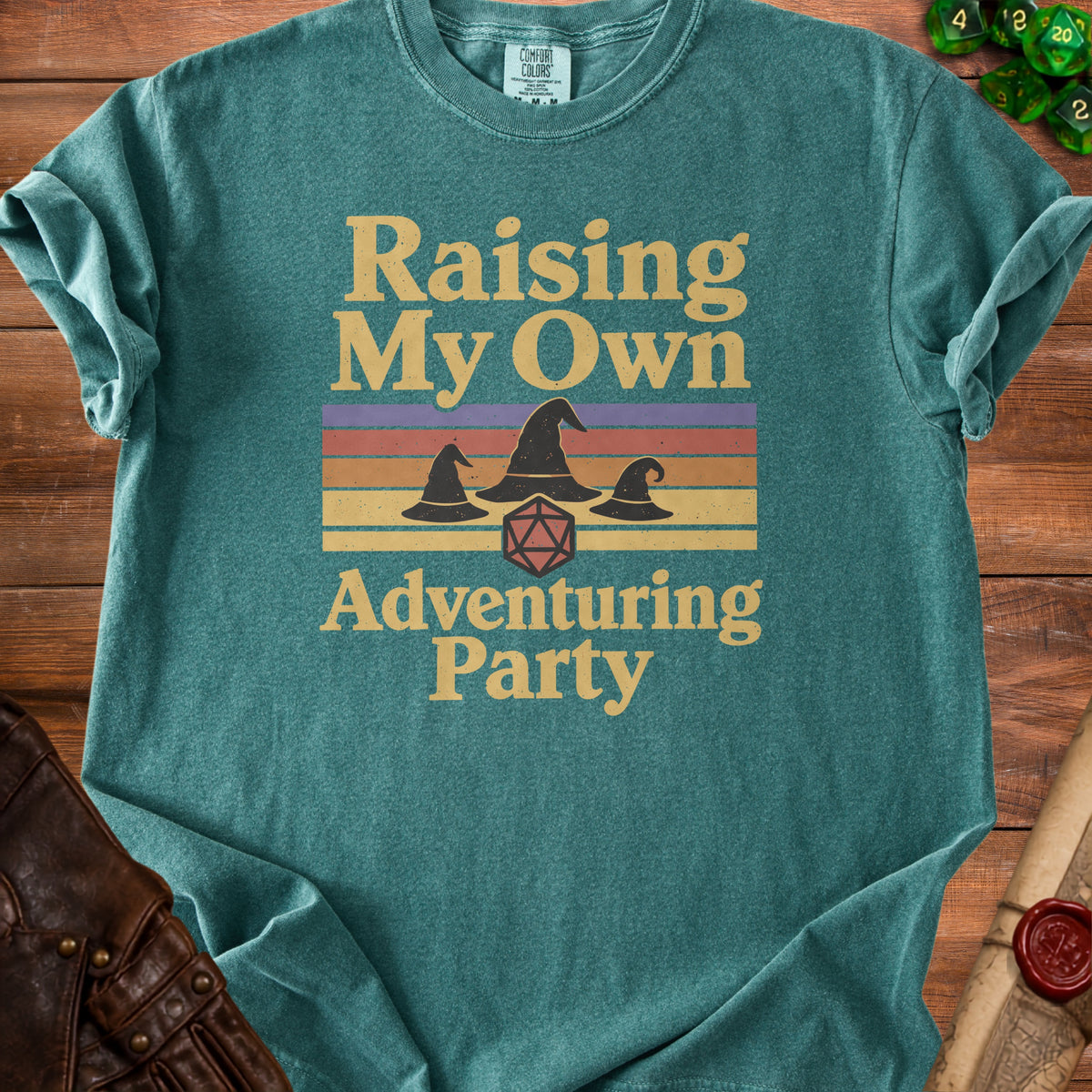 Teal t-shirt with "Raising My Own Adventuring Party" text and wizard hats.