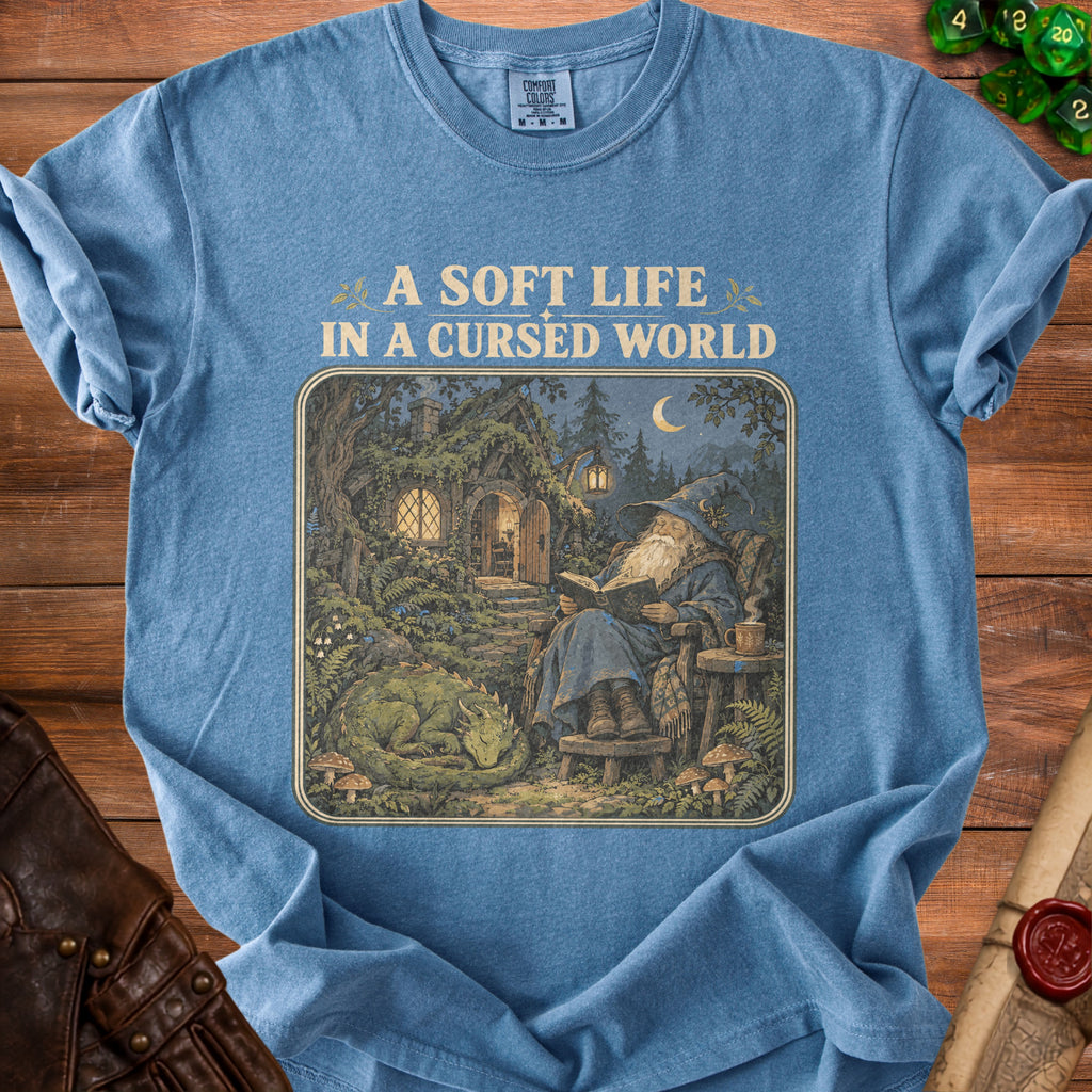 Blue t-shirt with wizard, sleeping dragon, and "A Soft Life In A Cursed World" text.