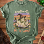Green t-shirt with a frog wearing a wizard hat and drinking coffee, with text "emotionally IN THE SWAMP".