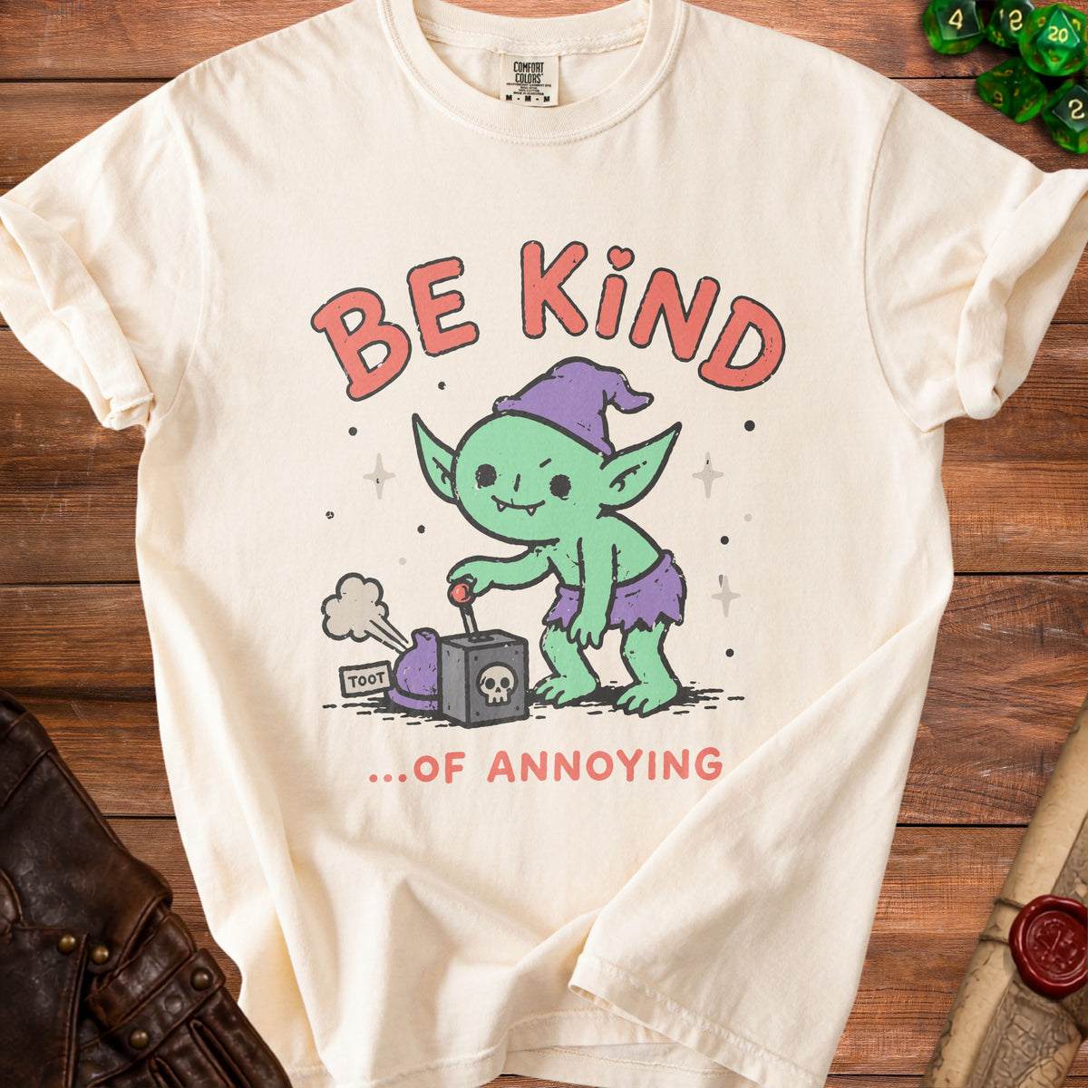 Cream t-shirt with a green goblin pushing a button labeled "TOOT" next to a skull.