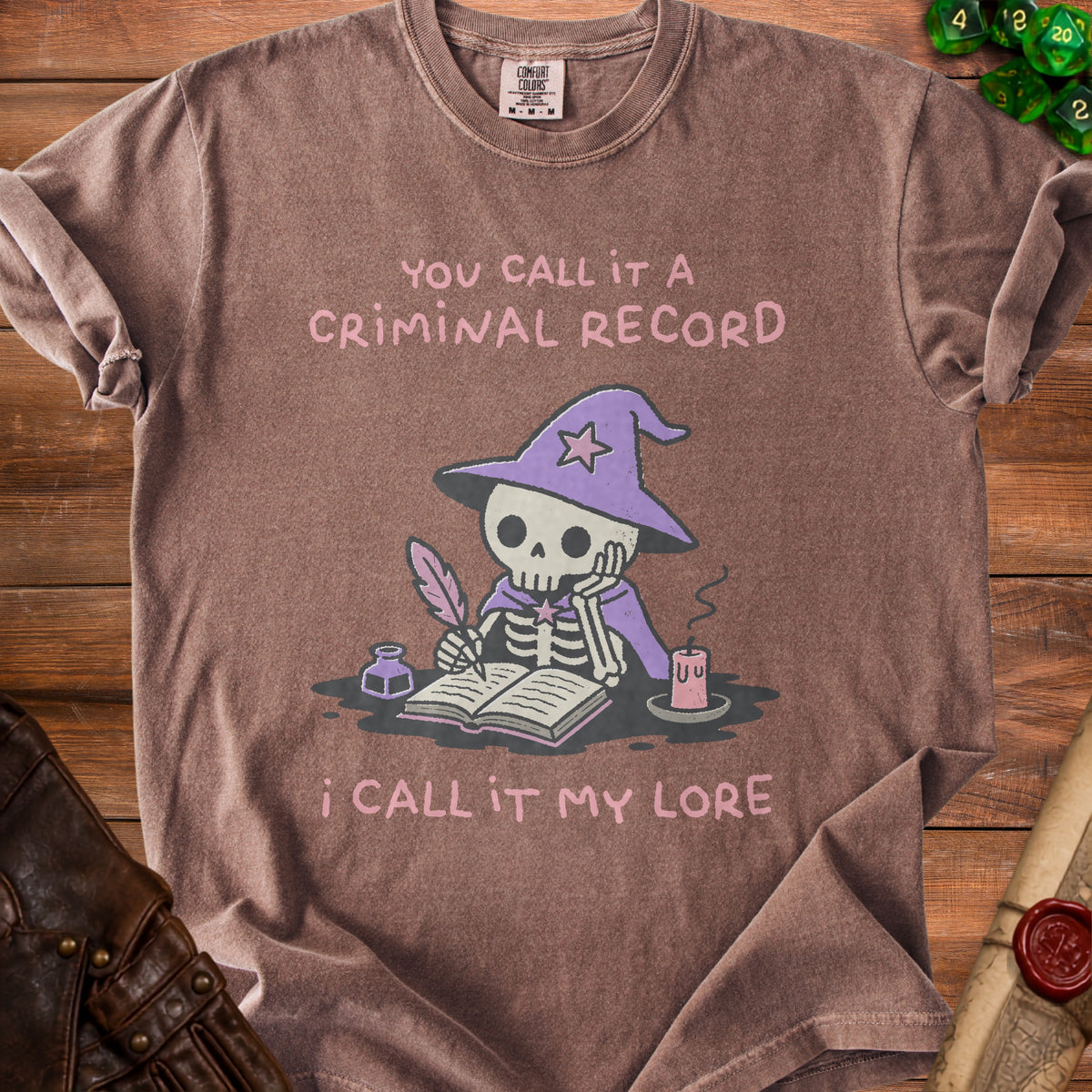 Brown t-shirt with skeleton wizard writing, "You call it a criminal record, I call it my lore."