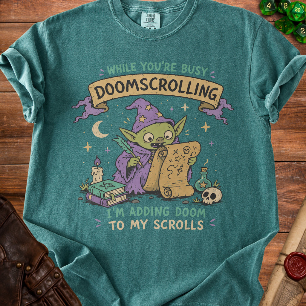 Green t-shirt graphic of a goblin wizard adding doom to his scrolls.