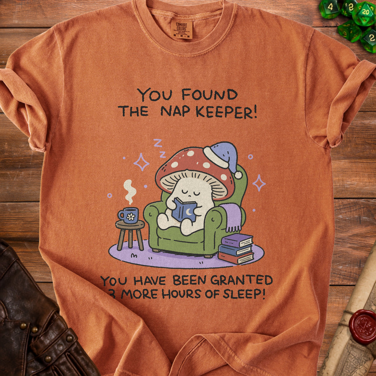 Orange t-shirt with cartoon mushroom reading, "You found the nap keeper! You have been granted 3 more hours of sleep!"