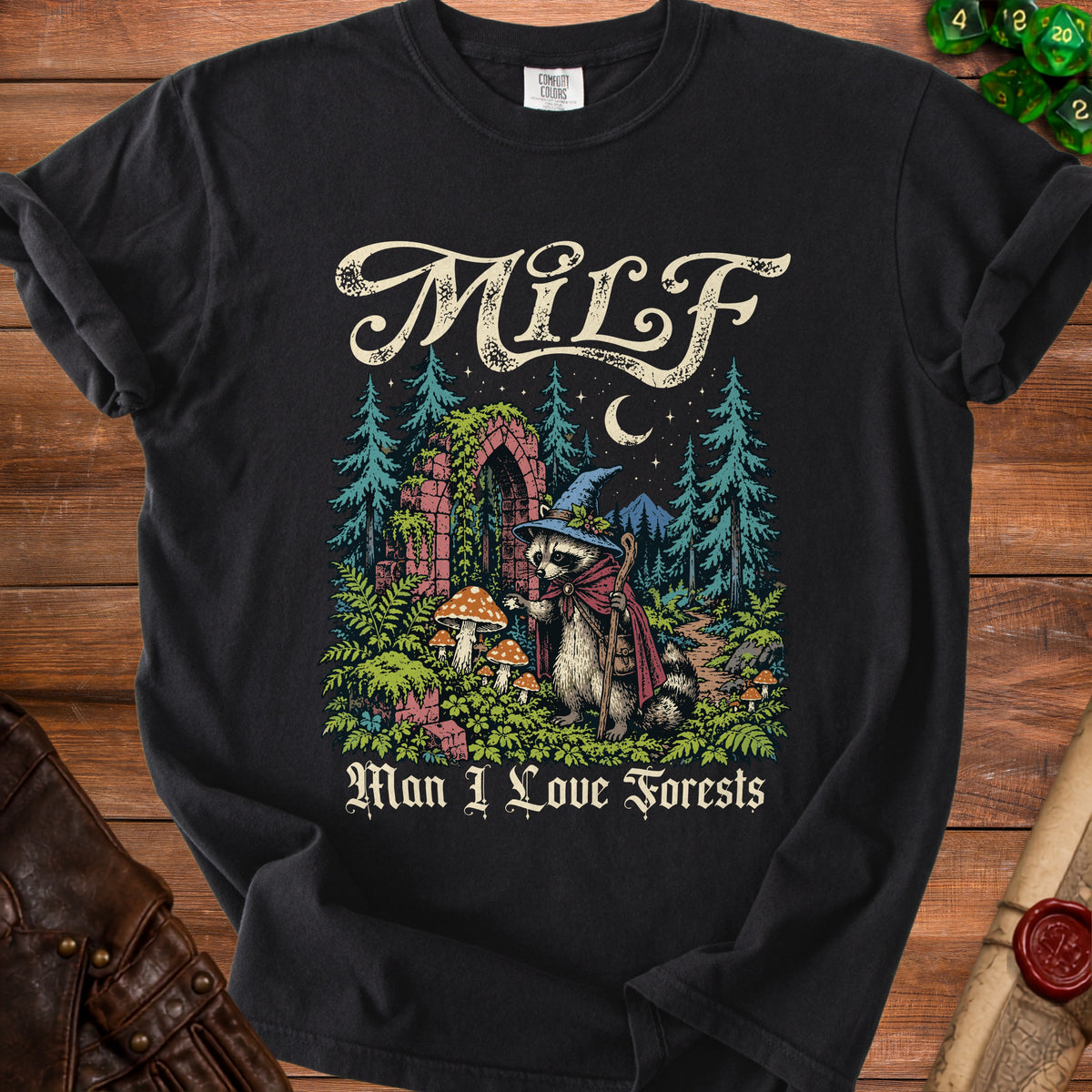 Black t-shirt with a graphic of a raccoon in a wizard hat and "Man I Love Forests" text.